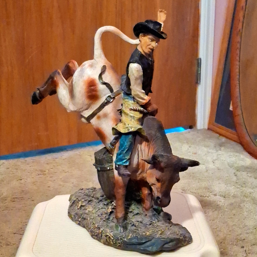 A cowboy riding a bucking bull statue